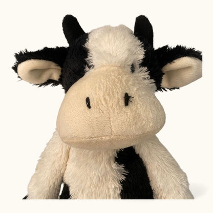 Plush cow toy with black and white pattern on a white background