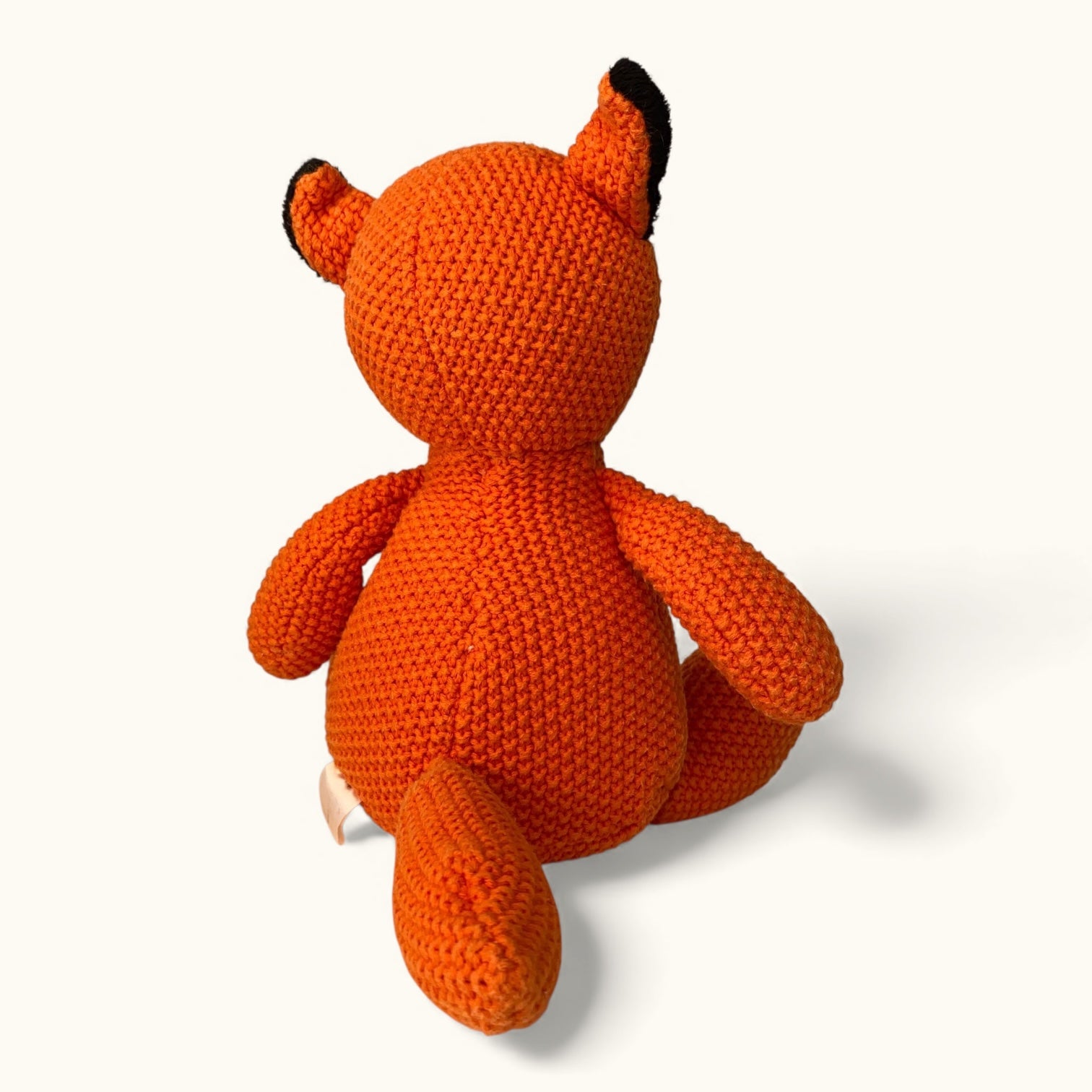 Knitted orange fox toy on a white background