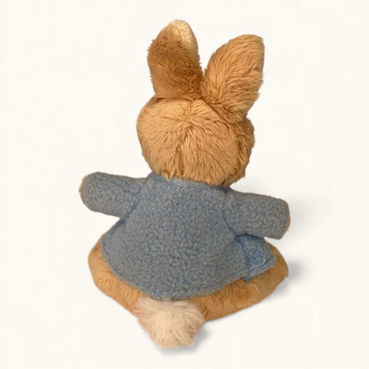 Plush toy rabbit wearing a gray coat on a white background