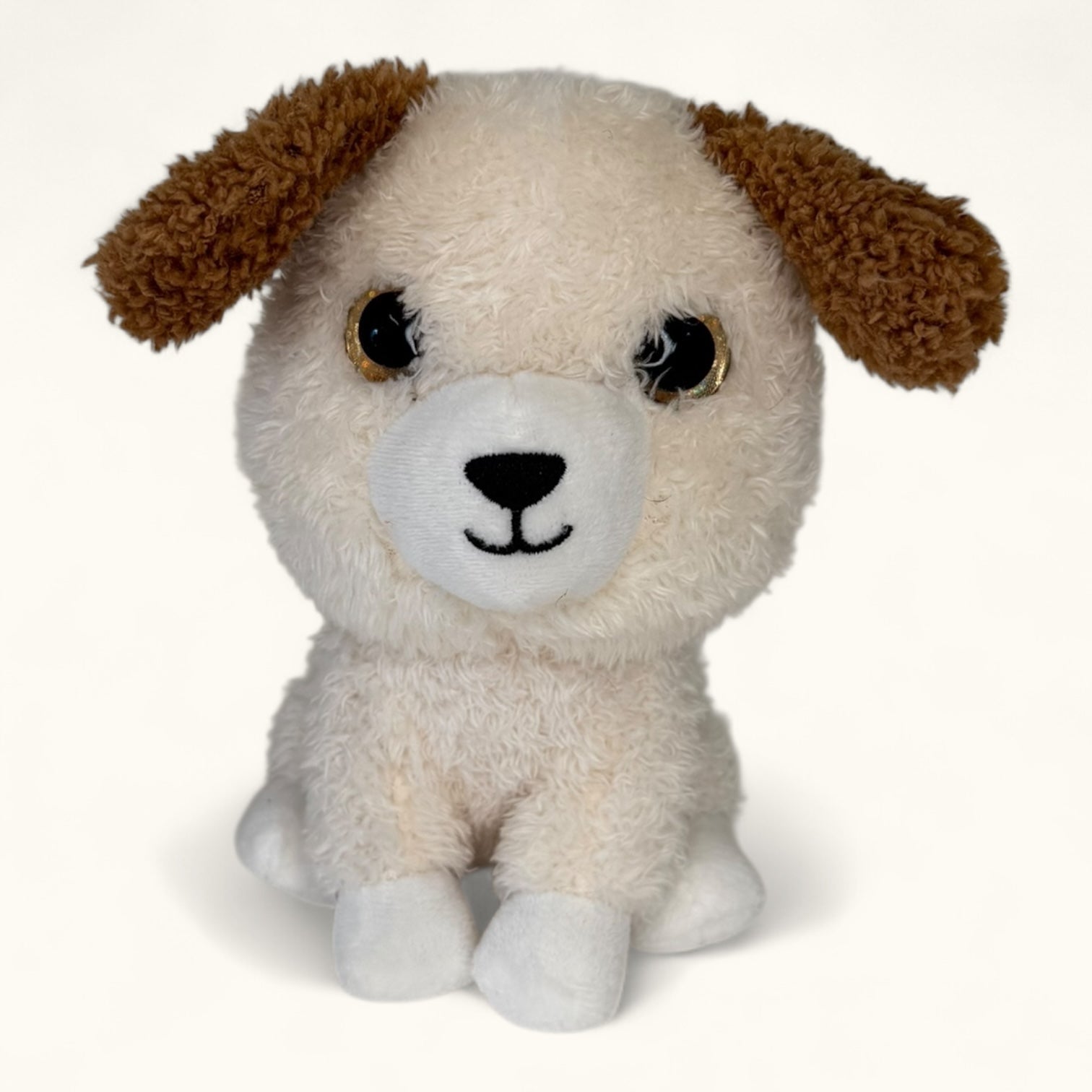 Plush toy dog with brown ears and white face on a white background