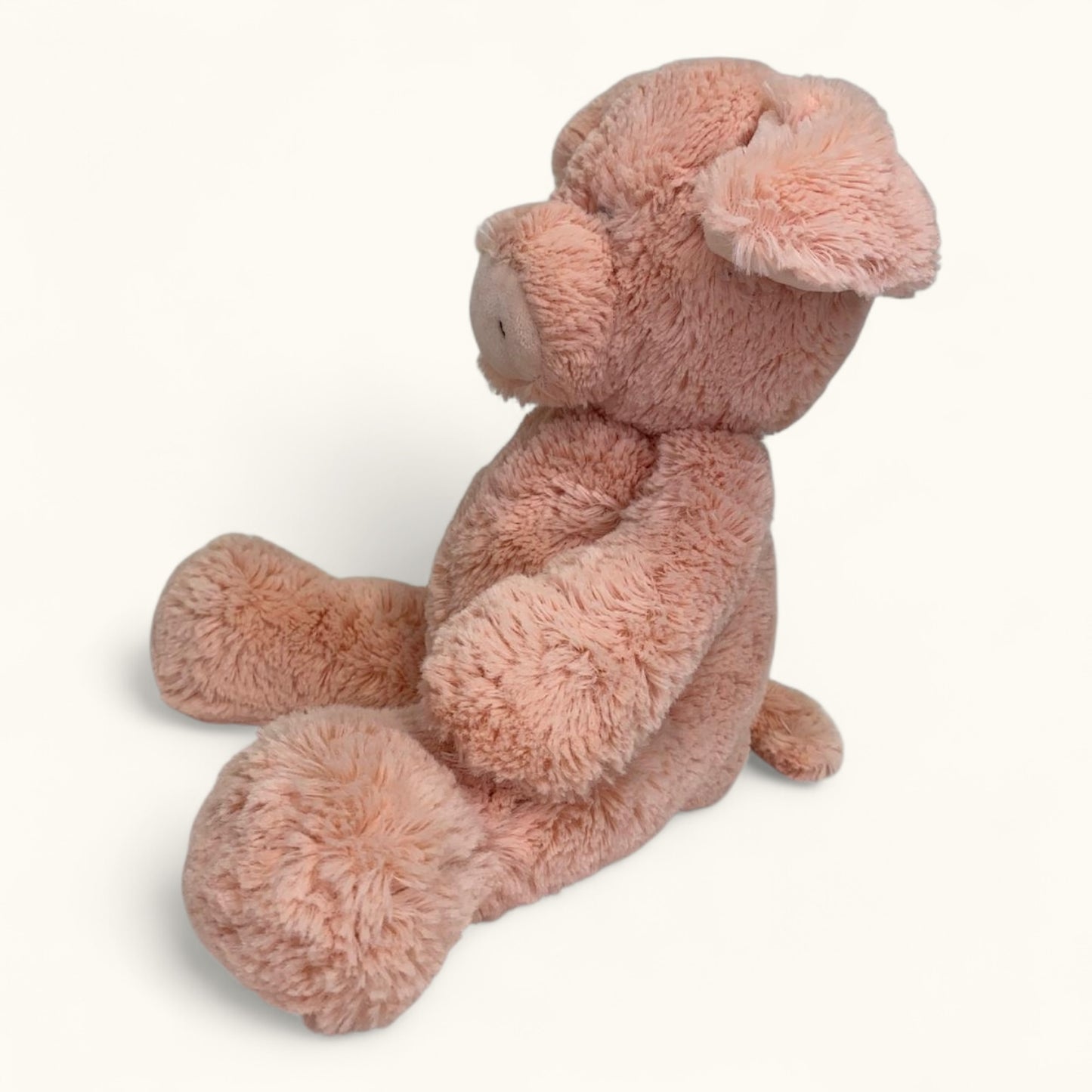 Plush toy pig in pink on a white background