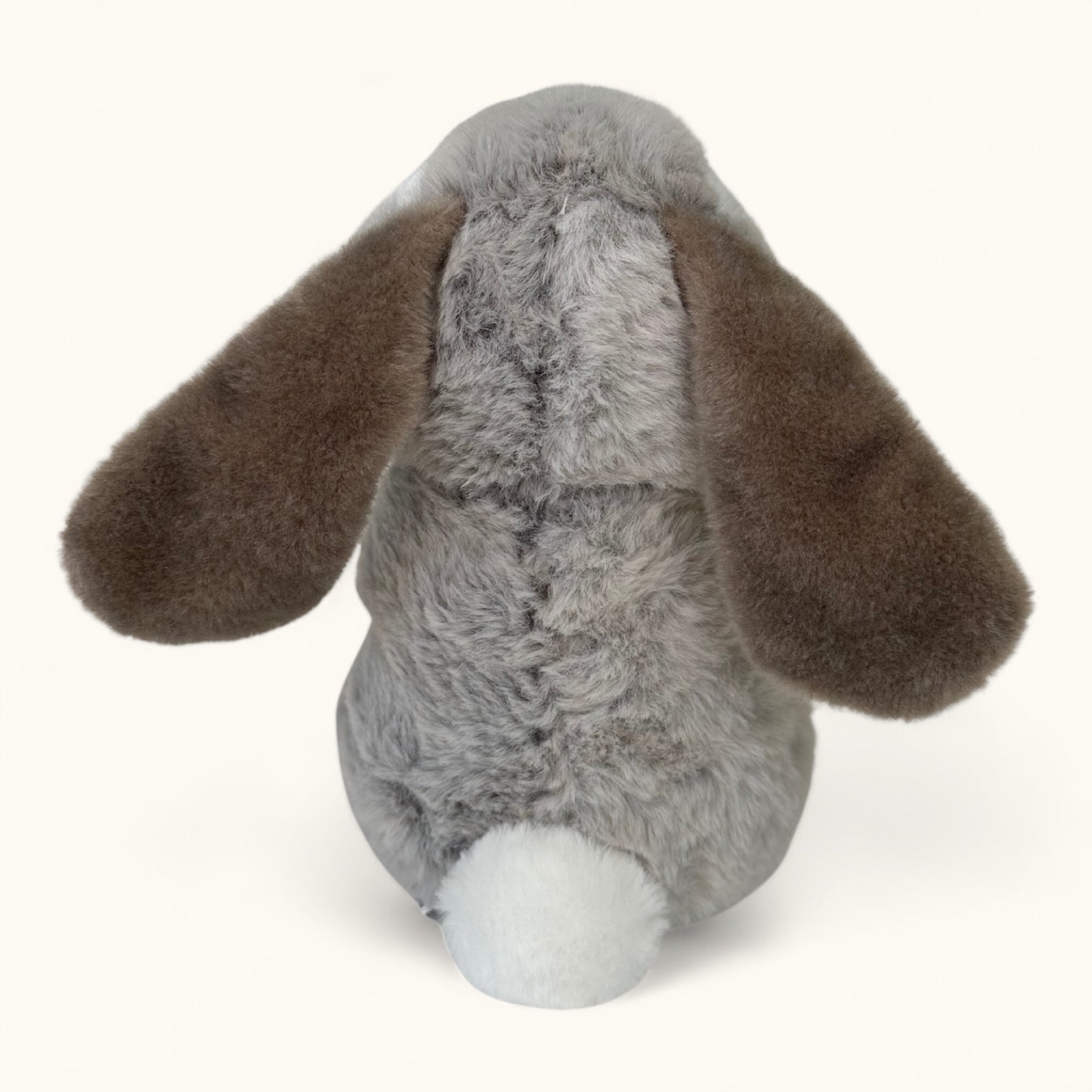Plush toy rabbit with gray body and brown ears on a white background