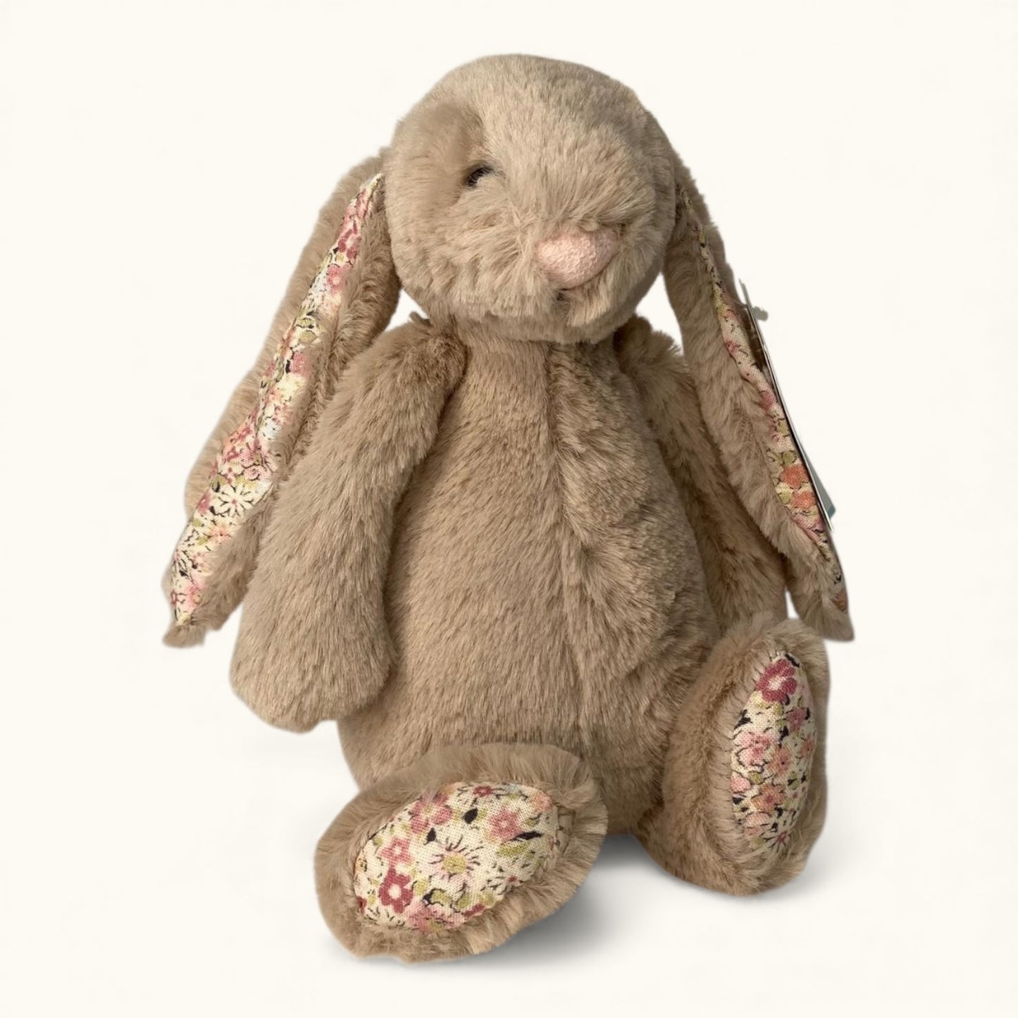 Floral-patterned plush rabbit toy on a white background