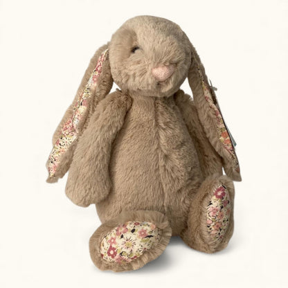 Floral-patterned plush rabbit toy on a white background