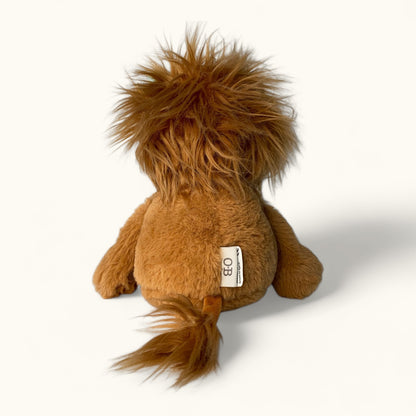 Plush lion toy with a visible brand label on a white background