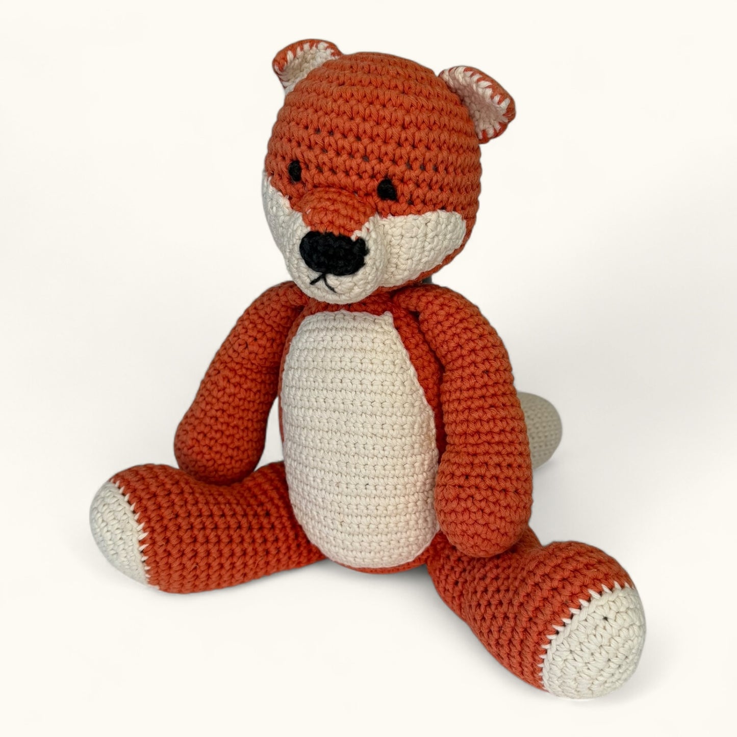 Crocheted fox toy on a white background