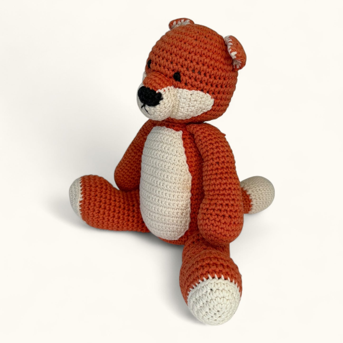 Crocheted fox toy on a white background