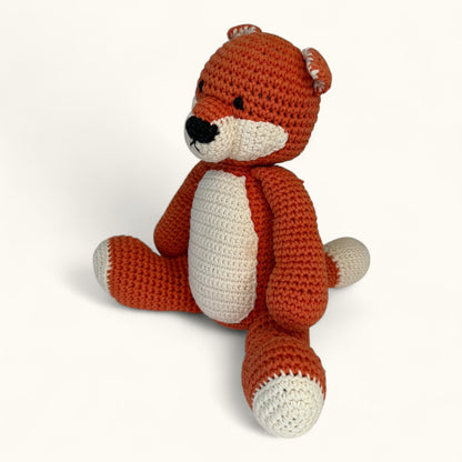 Crocheted fox toy on a white background