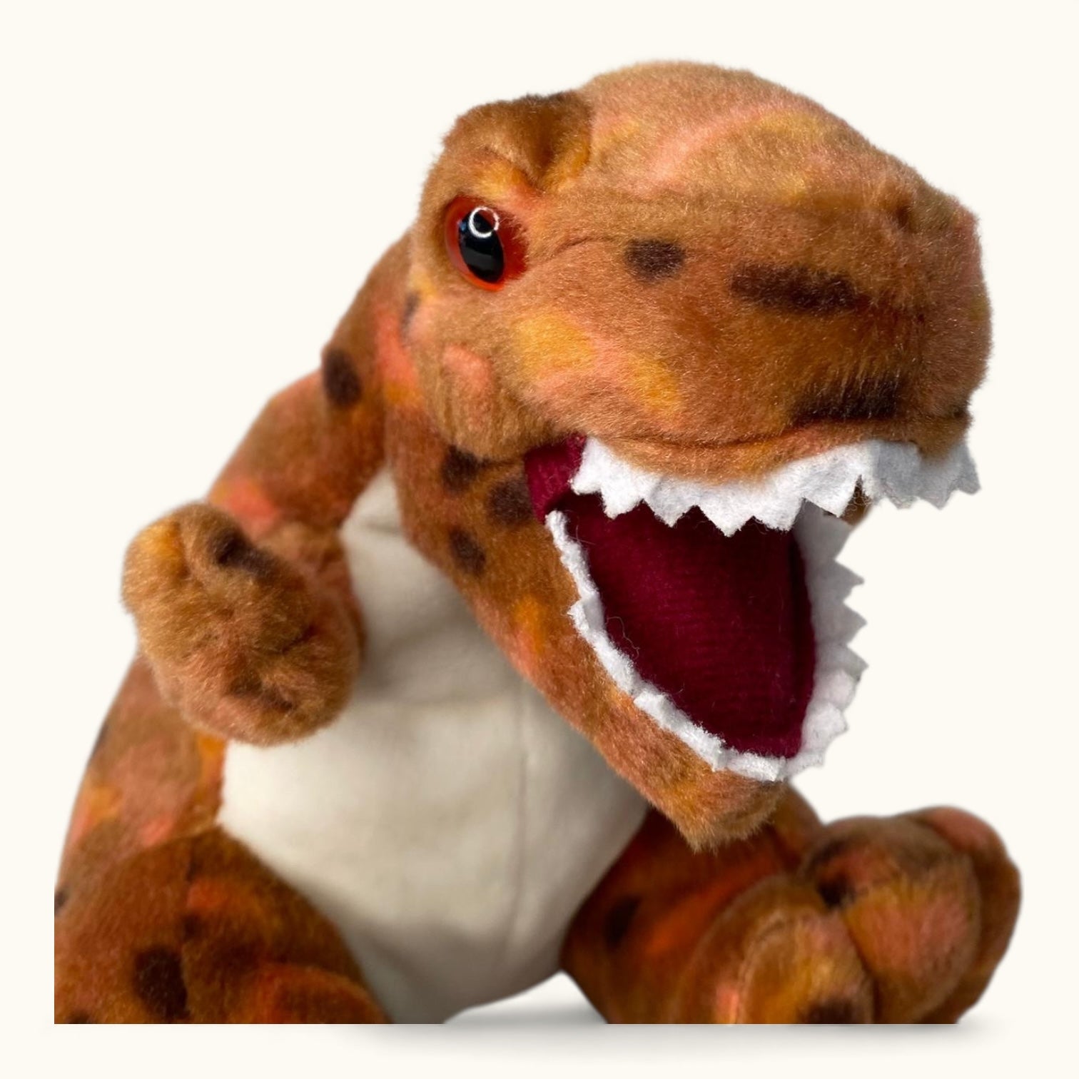 Plush dinosaur toy with open mouth on a white background