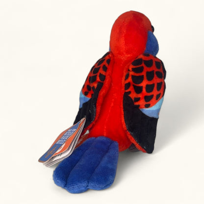 Plush toy parrot with red, blue, and black colors on a white background
