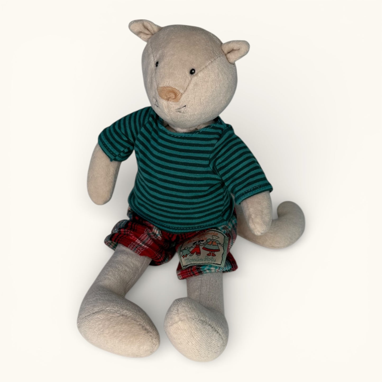 Stuffed animal toy wearing a green striped shirt and plaid shorts on a white background