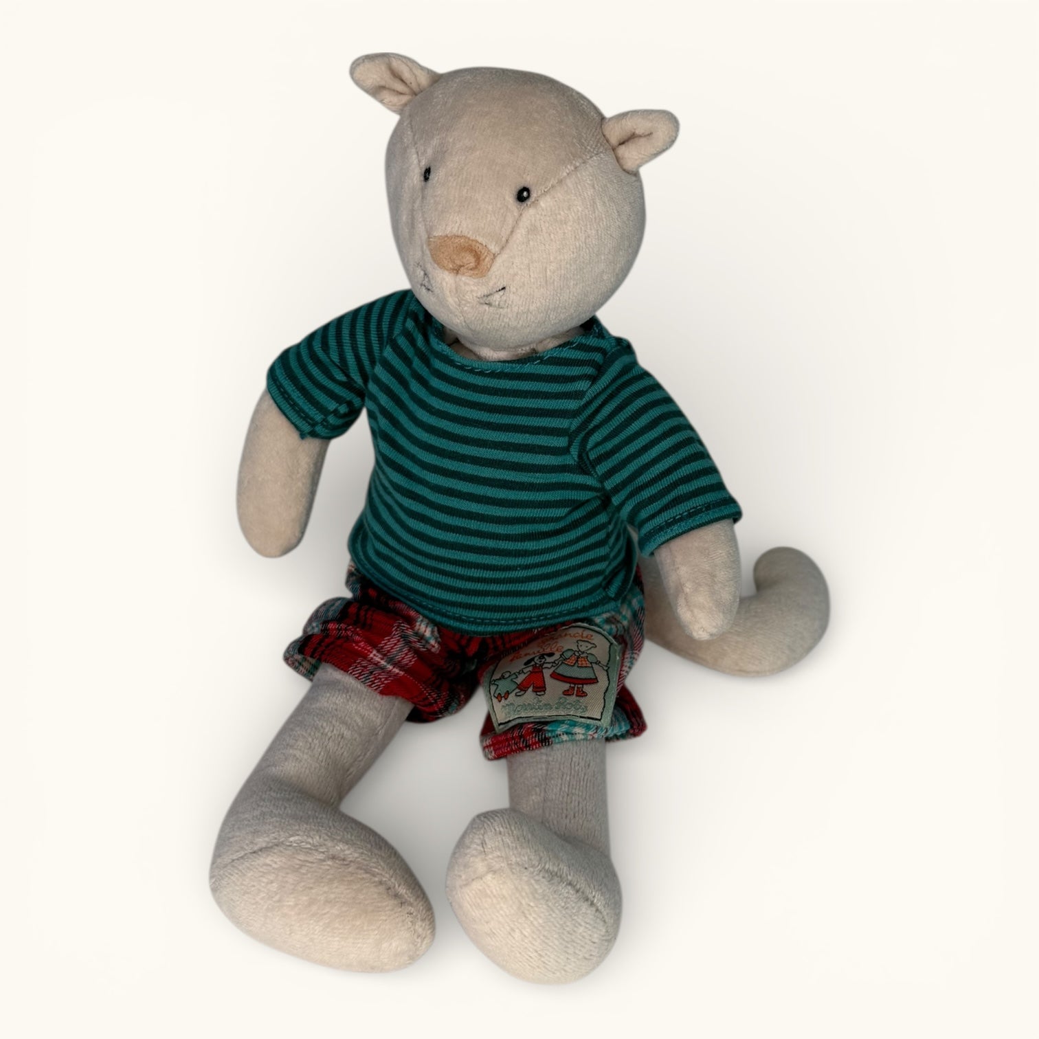 Stuffed animal toy wearing a green striped shirt and plaid shorts on a white background
