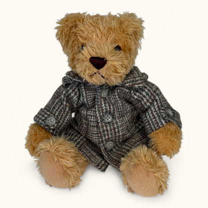 Teddy bear wearing a brown coat on a white background