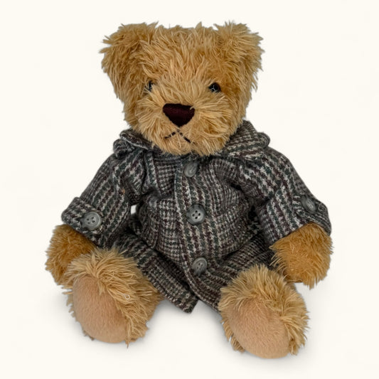 Teddy bear wearing a brown coat on a white background