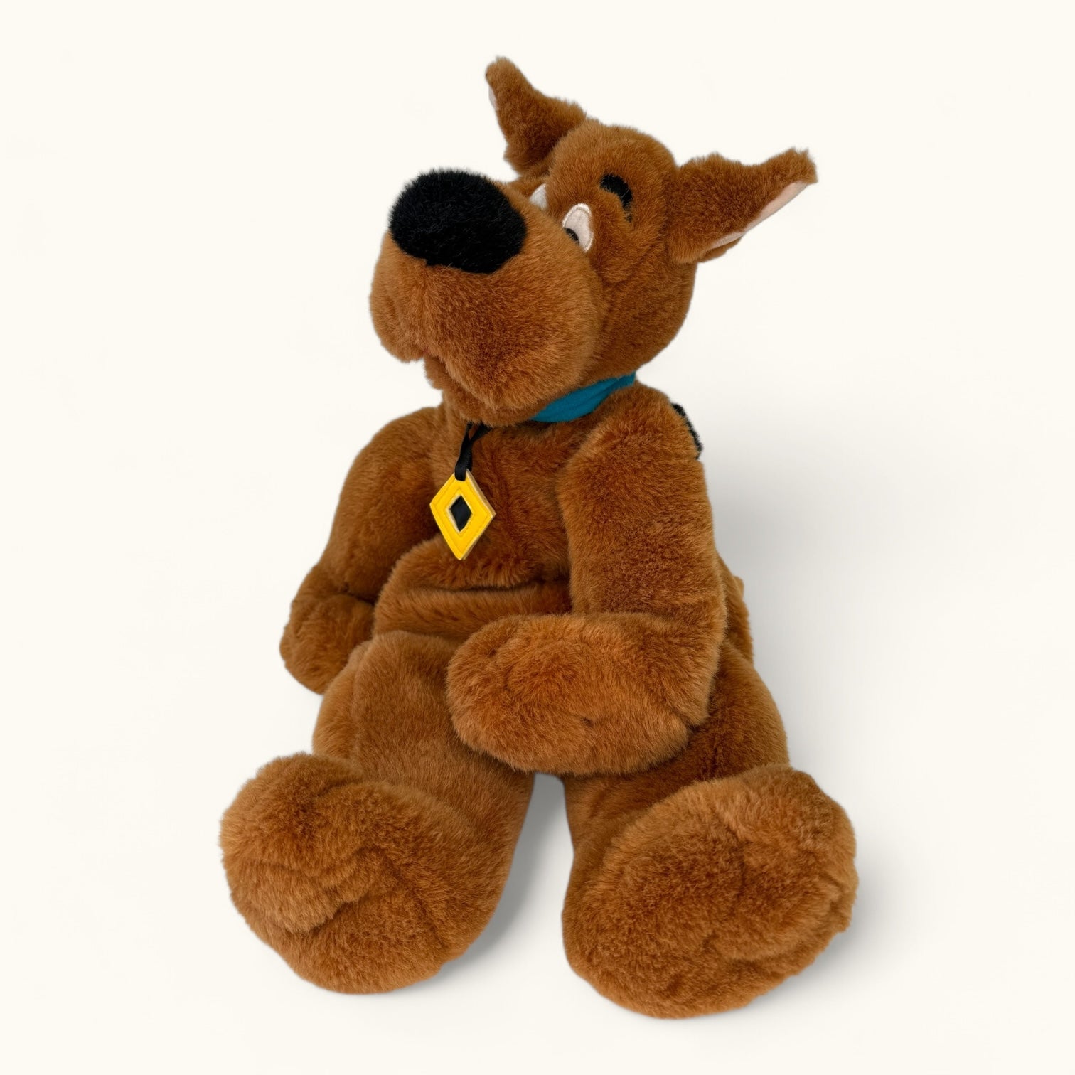 Plush toy resembling a cartoon character with a yellow tag on a white background