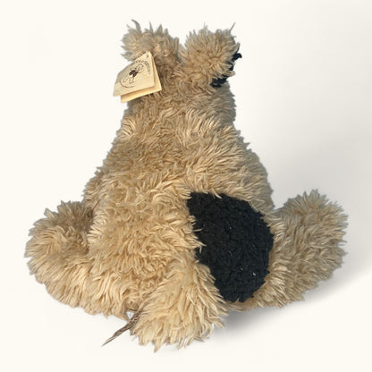 Plush toy resembling a dog with a black nose on a white background