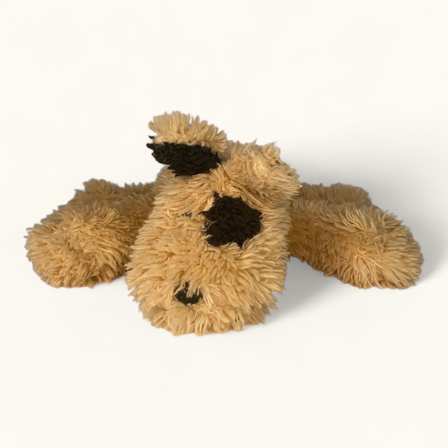 Plush dog toy with brown fur and black accents on a white background