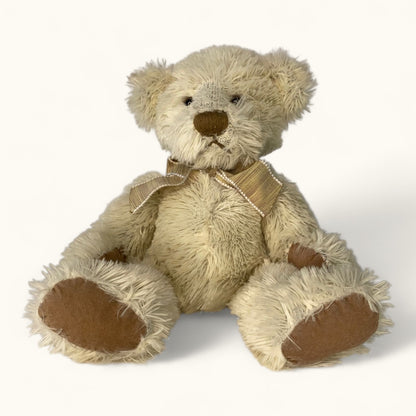 Stuffed teddy bear with a bow tie on a white background