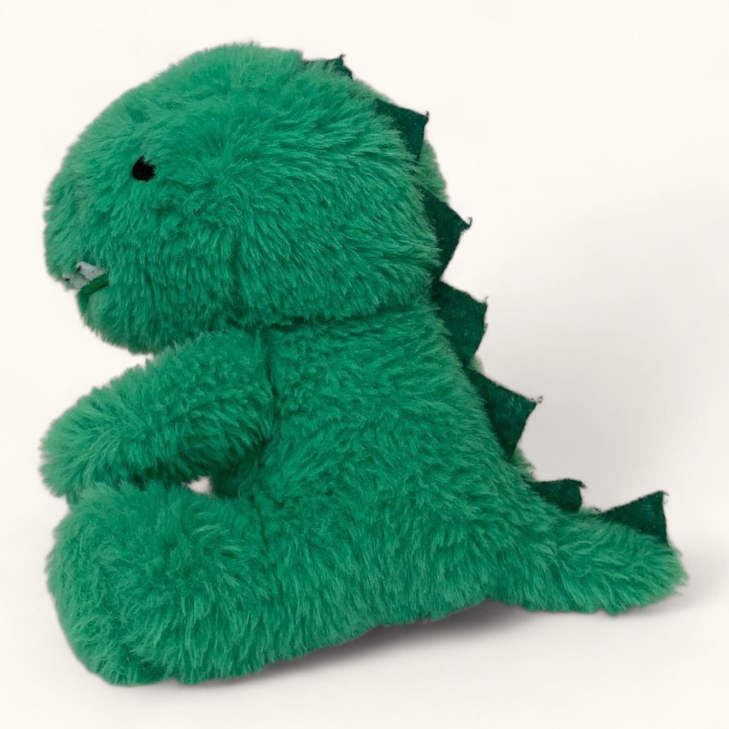 Green plush dinosaur toy on a white background