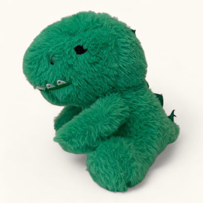 Green plush dinosaur toy on a white background