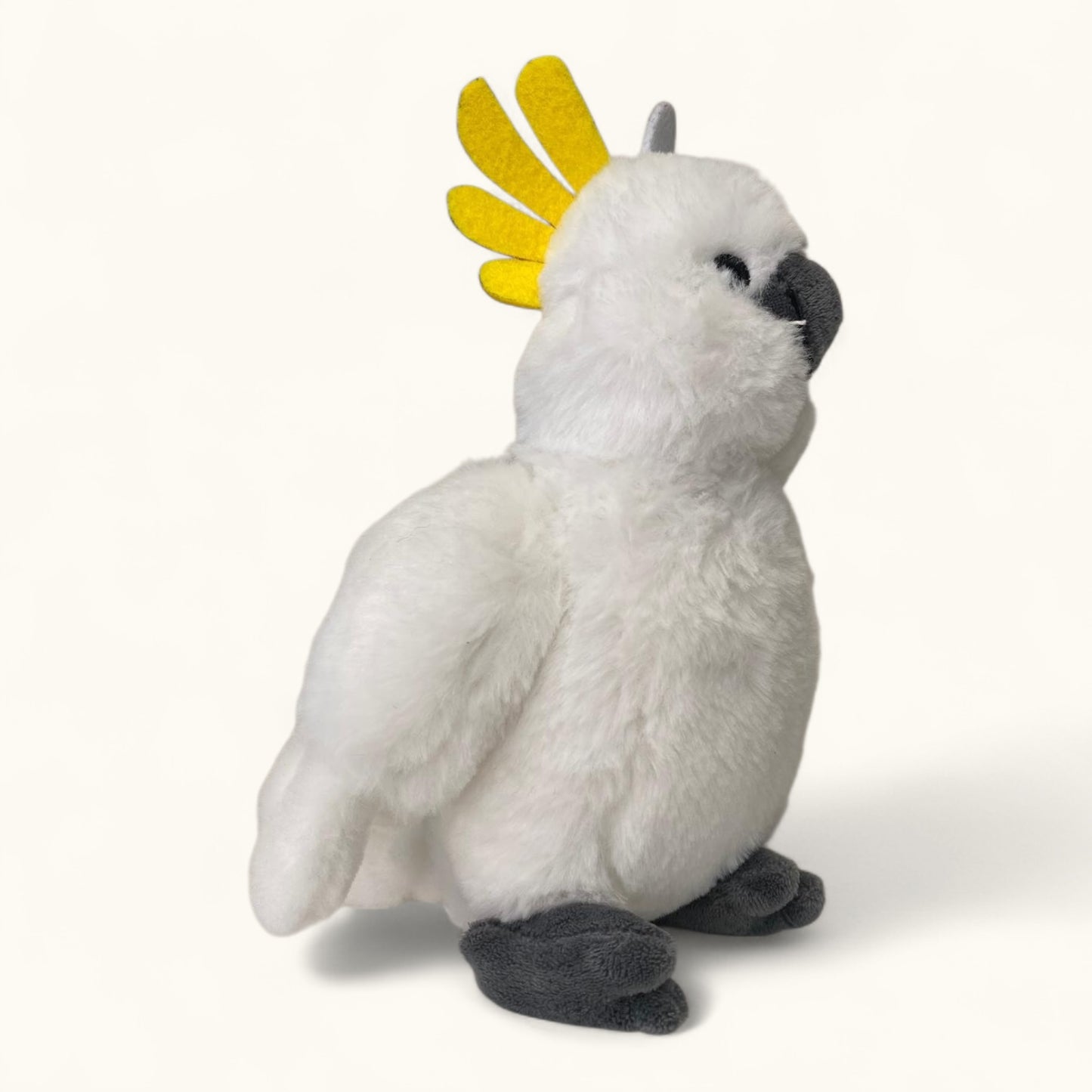 Plush toy of a white cockatoo with a yellow crest on a white background