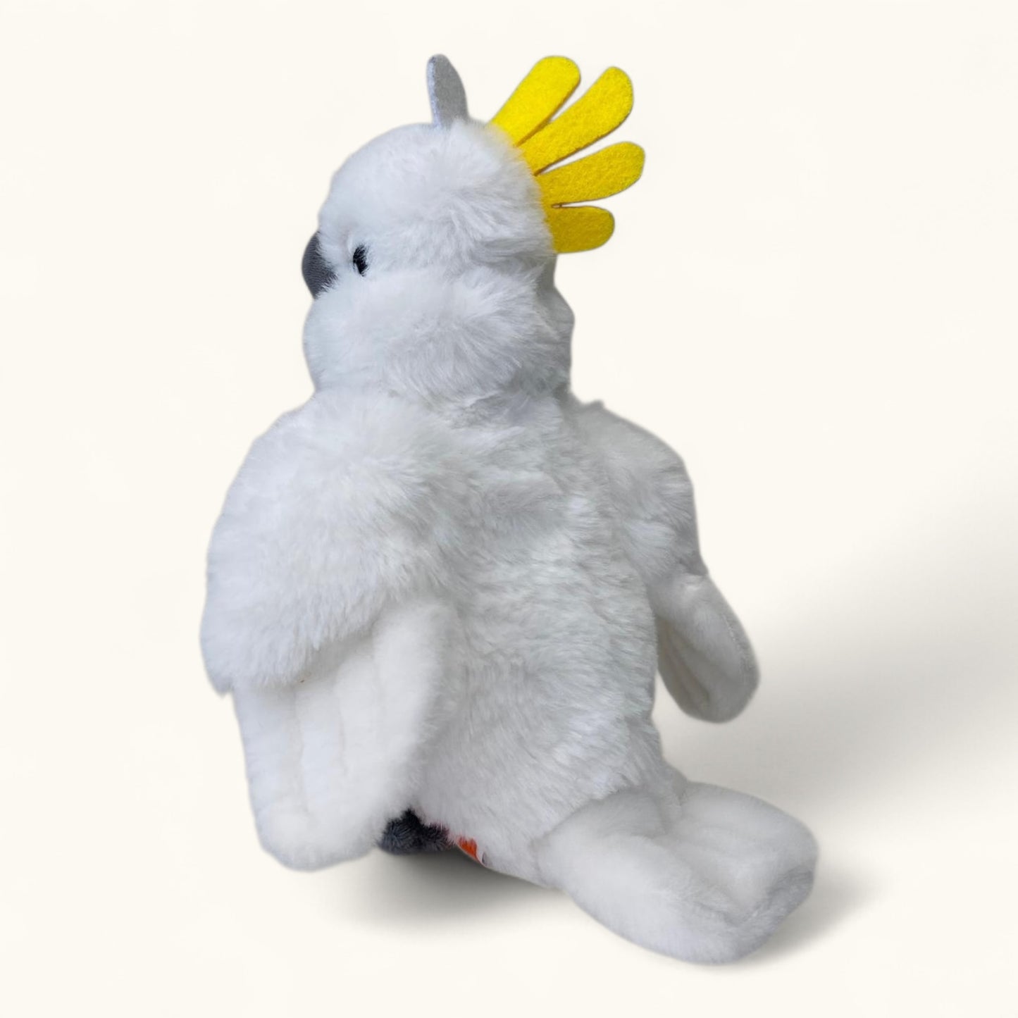 Plush toy of a white cockatoo with a yellow crest on a white background