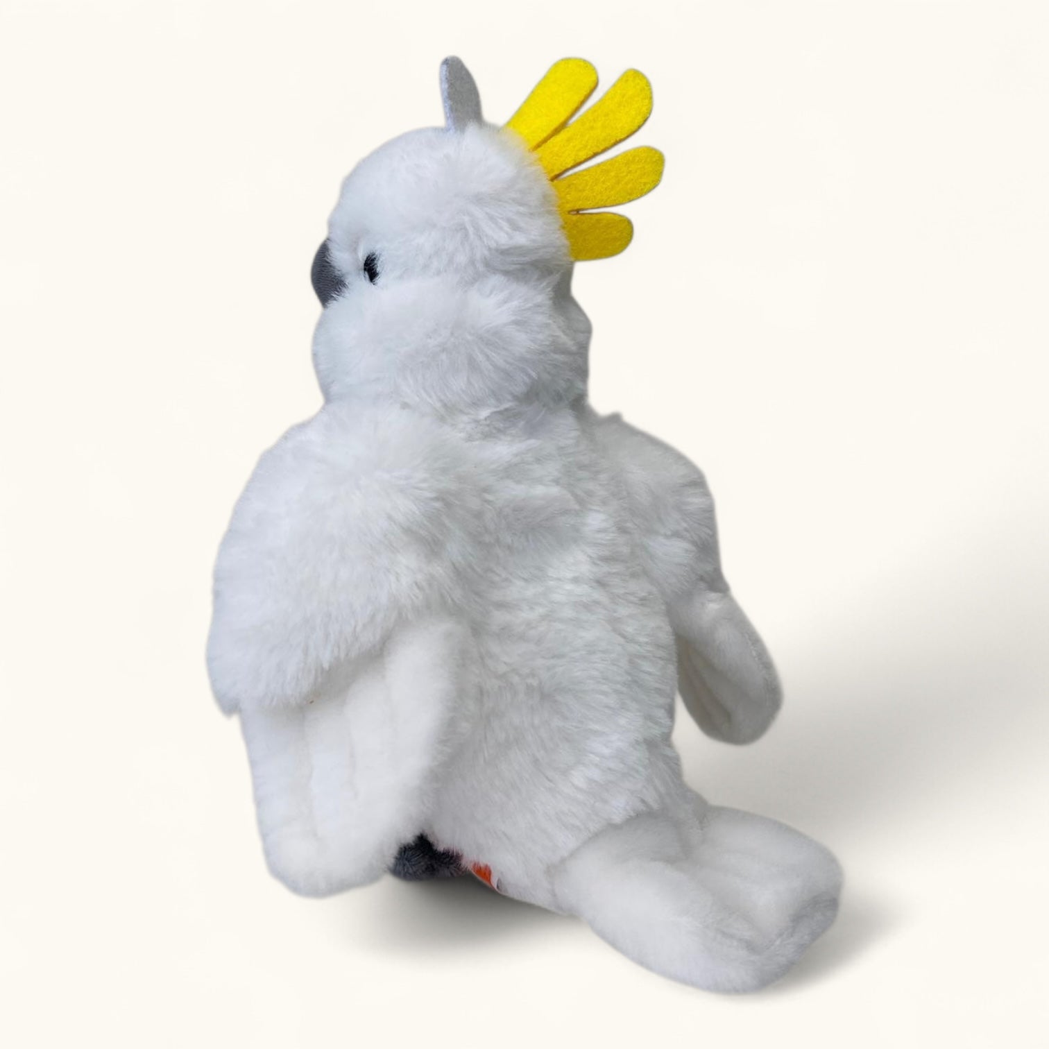 Plush toy of a white cockatoo with a yellow crest on a white background