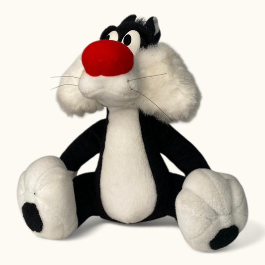 Plush toy of a cartoon character with a red nose on a white background
