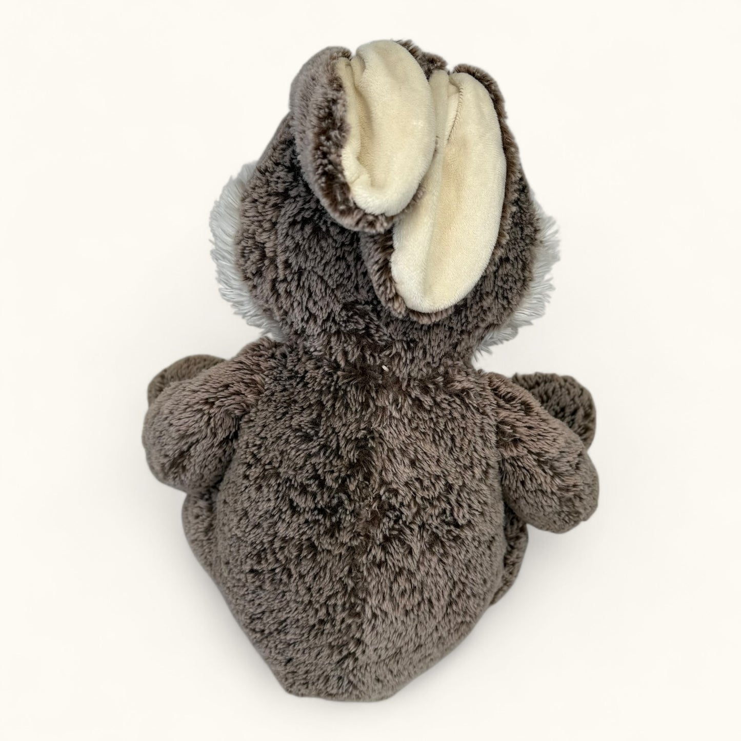Plush toy resembling a dog in a hoodie with white interior on a white background
