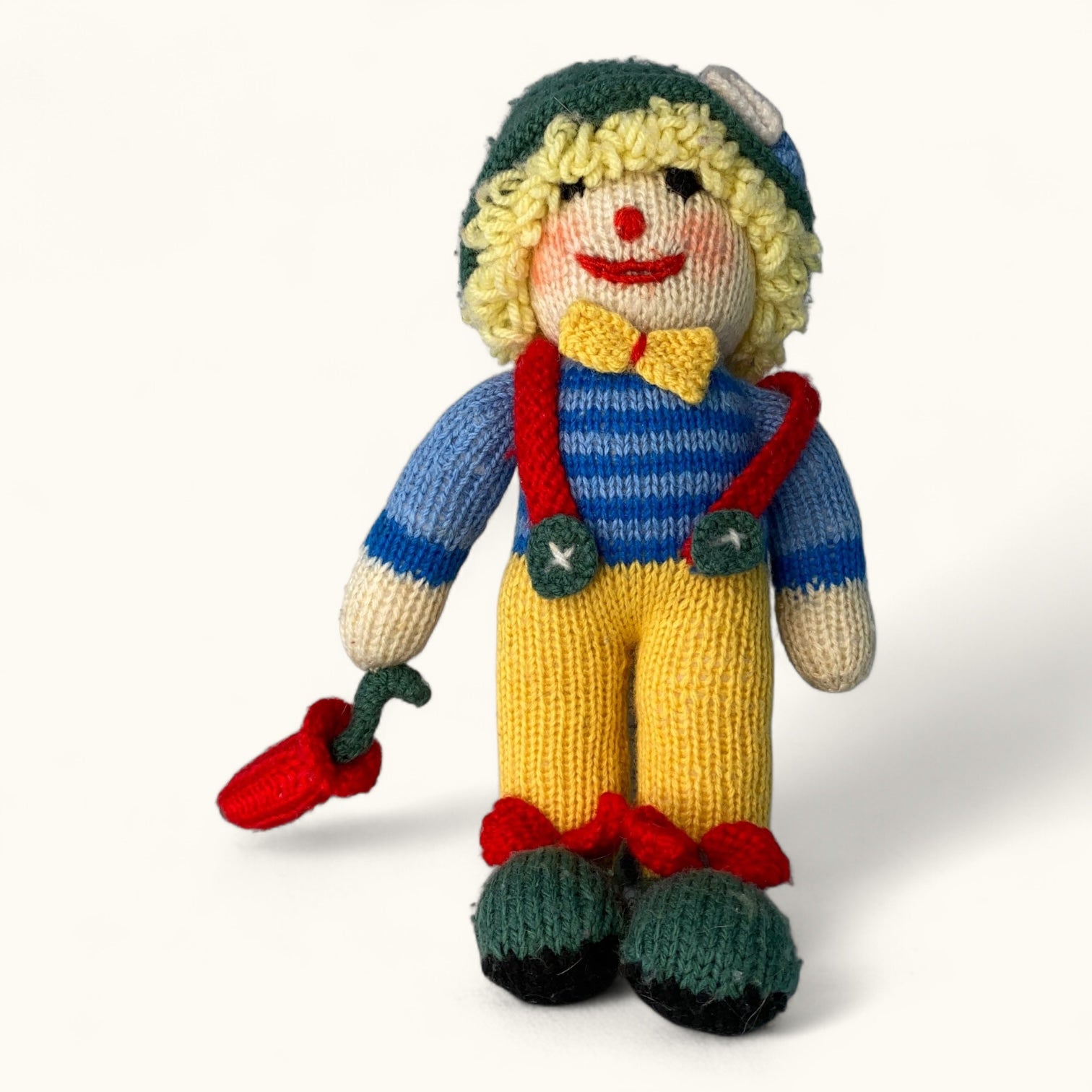 Knitted toy with a colorful outfit on a white background